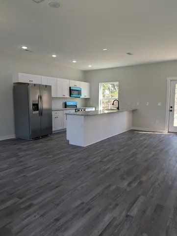 a kitchen with stainless steel appliances wooden floors and wooden cabinets