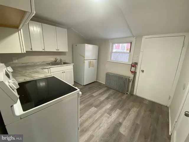 a kitchen with a refrigerator sink and cabinets