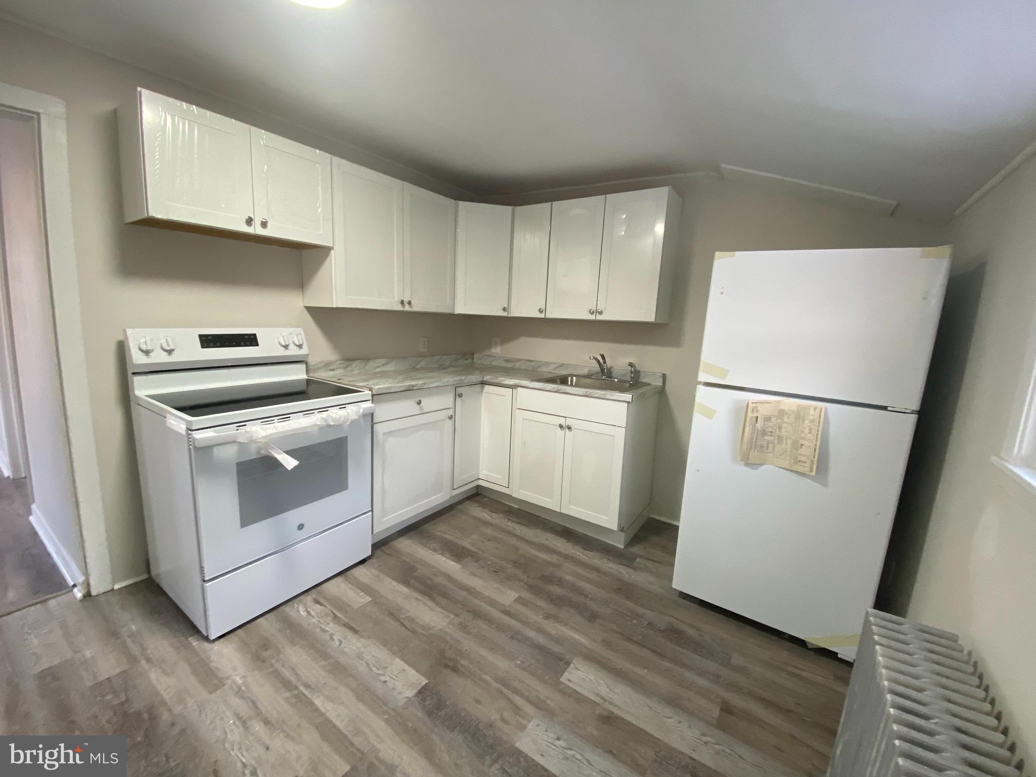 476 North Pearl Street Bridgeton, NJ 08302 - Photo 8 of 18 a kitchen with white cabinets and white appliances