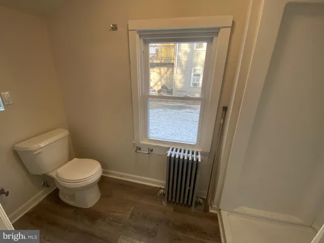 a white toilet sitting next to a window