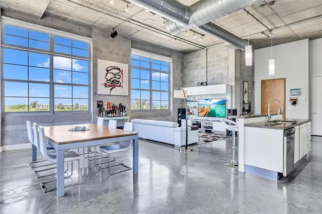 a view of a dining room with furniture large windows and wooden floor