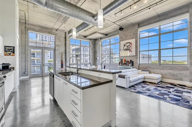 a kitchen with granite countertop a sink stove and cabinets