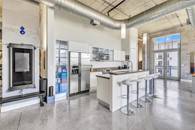 a kitchen that has a lot of cabinets in it and stainless steel appliances