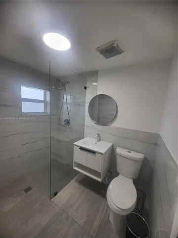 a bathroom with a toilet sink a shower and mirror