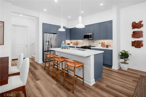 a kitchen with stainless steel appliances granite countertop a sink a stove and a refrigerator