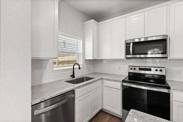 a kitchen with appliances a sink and cabinets