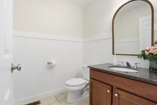 a bathroom with a granite countertop sink a toilet and mirror