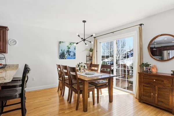 a dining room with furniture a chandelier and wooden floor
