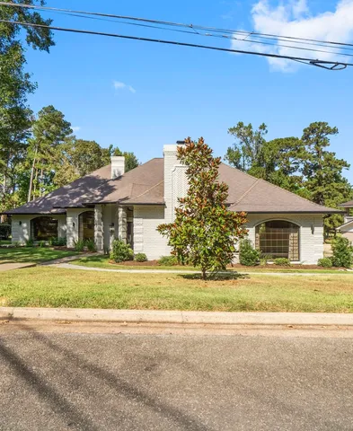 a front view of a house with a yard and trees