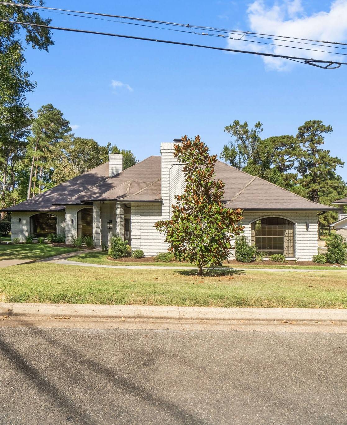 a front view of a house with a yard and trees