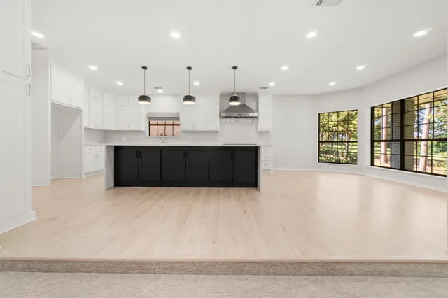 an empty room with a fireplace cabinet and a rug