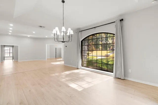 a large kitchen with stainless steel appliances kitchen island a large counter top a sink a stove and a window