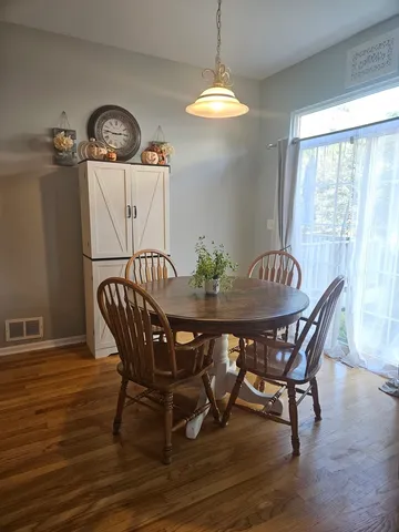 a view of a dining room with furniture wooden floor and chandelier