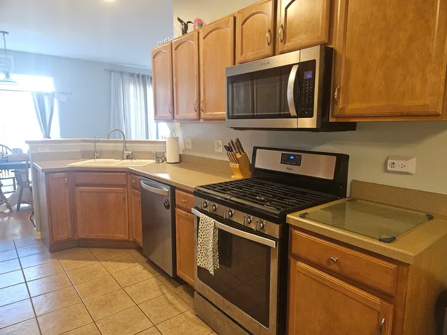 a kitchen with stainless steel appliances granite countertop a stove top oven microwave and cabinets
