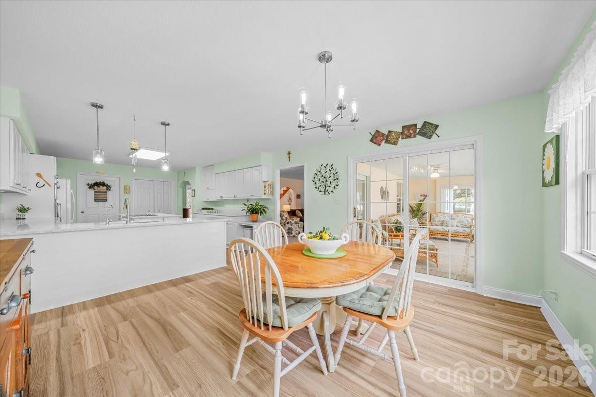 16601 Jefferson Place Fort Mill, SC 29708 - Photo 18 of 45 a dining room with wooden floor a chandelier a wooden table and chairs