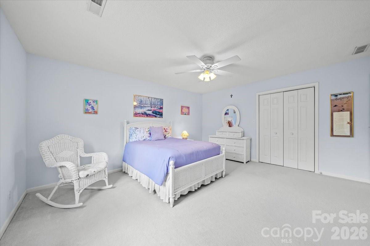 16601 Jefferson Place Fort Mill, SC 29708 - Photo 32 of 45 a spacious bedroom with a bed a chair and a chandelier