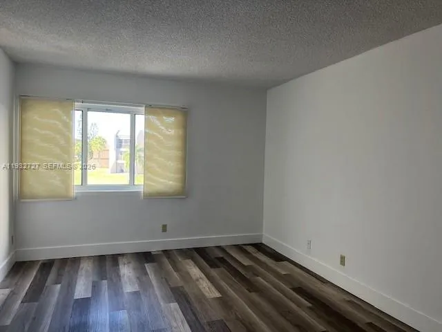 a view of a room with wooden floor and small window