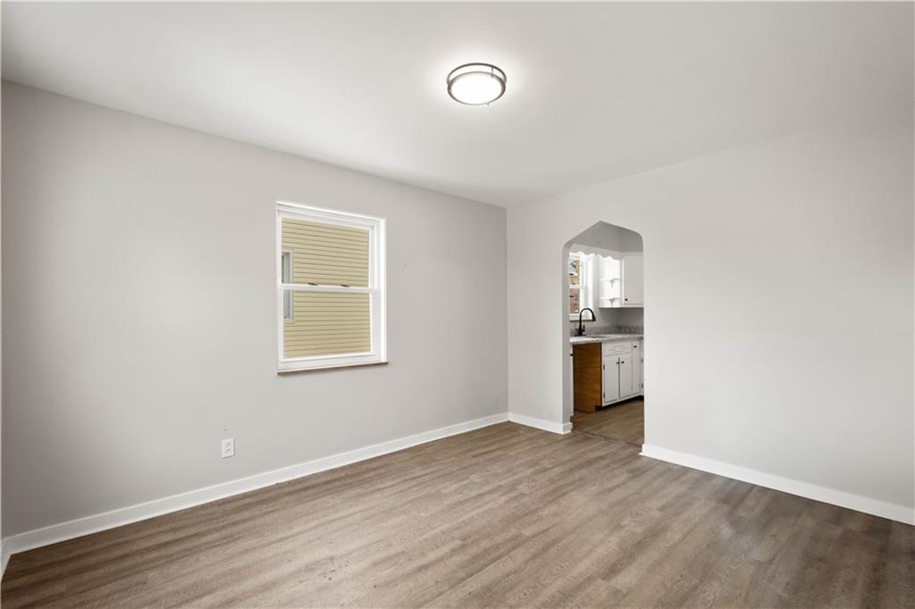 1613 Clarkton Street Pittsburgh, PA 15204 - Photo 8 of 23 wooden floor in an empty room with a kitchen