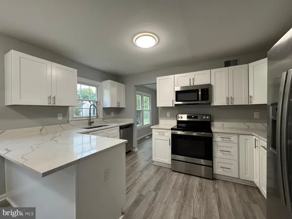 a kitchen with a sink a stove a microwave and cabinets