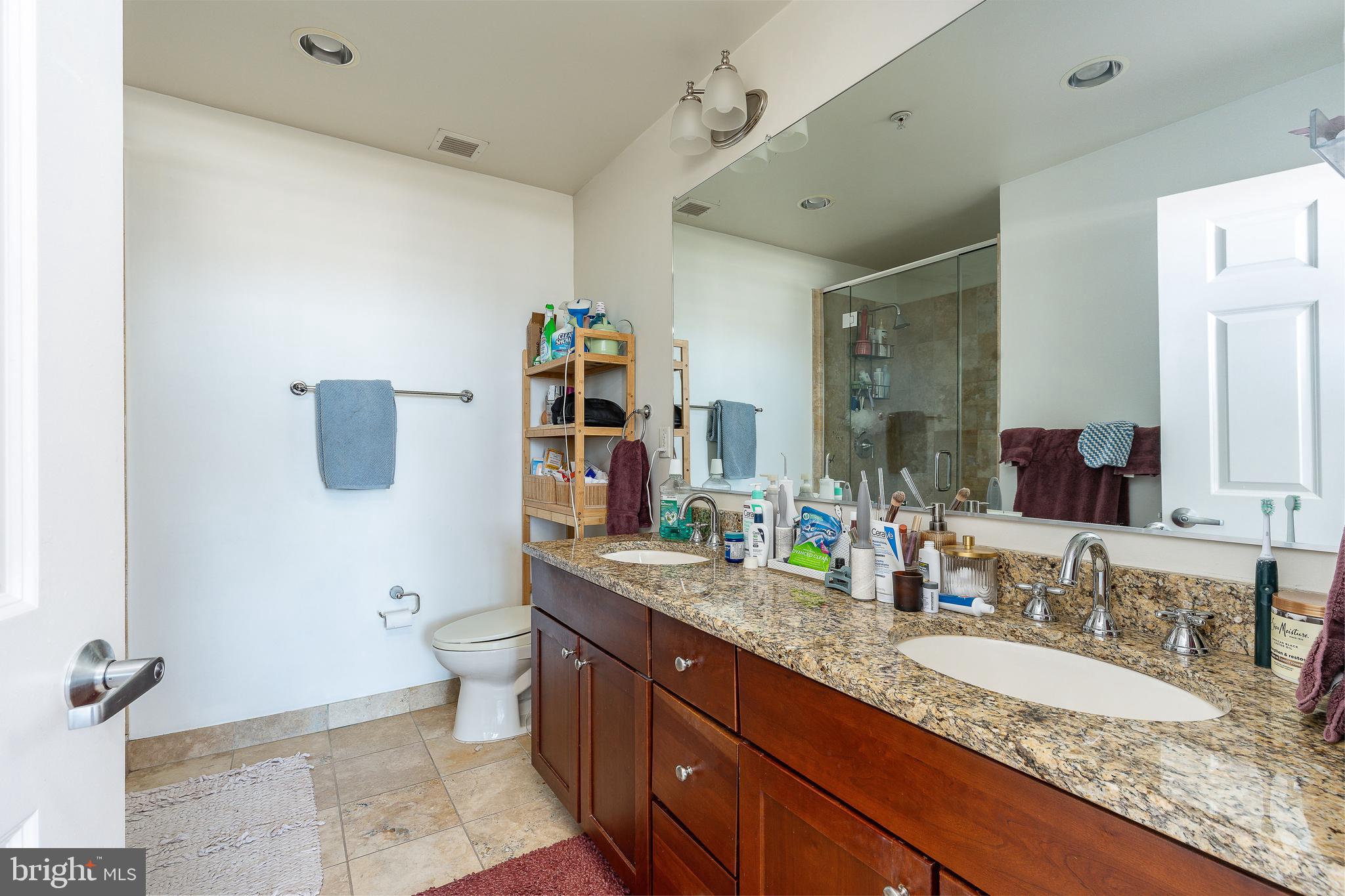 22 South Front Street, Unit 207 Philadelphia, PA 19106 - Photo 20 of 32 a bathroom with a granite countertop sink a toilet and a mirror