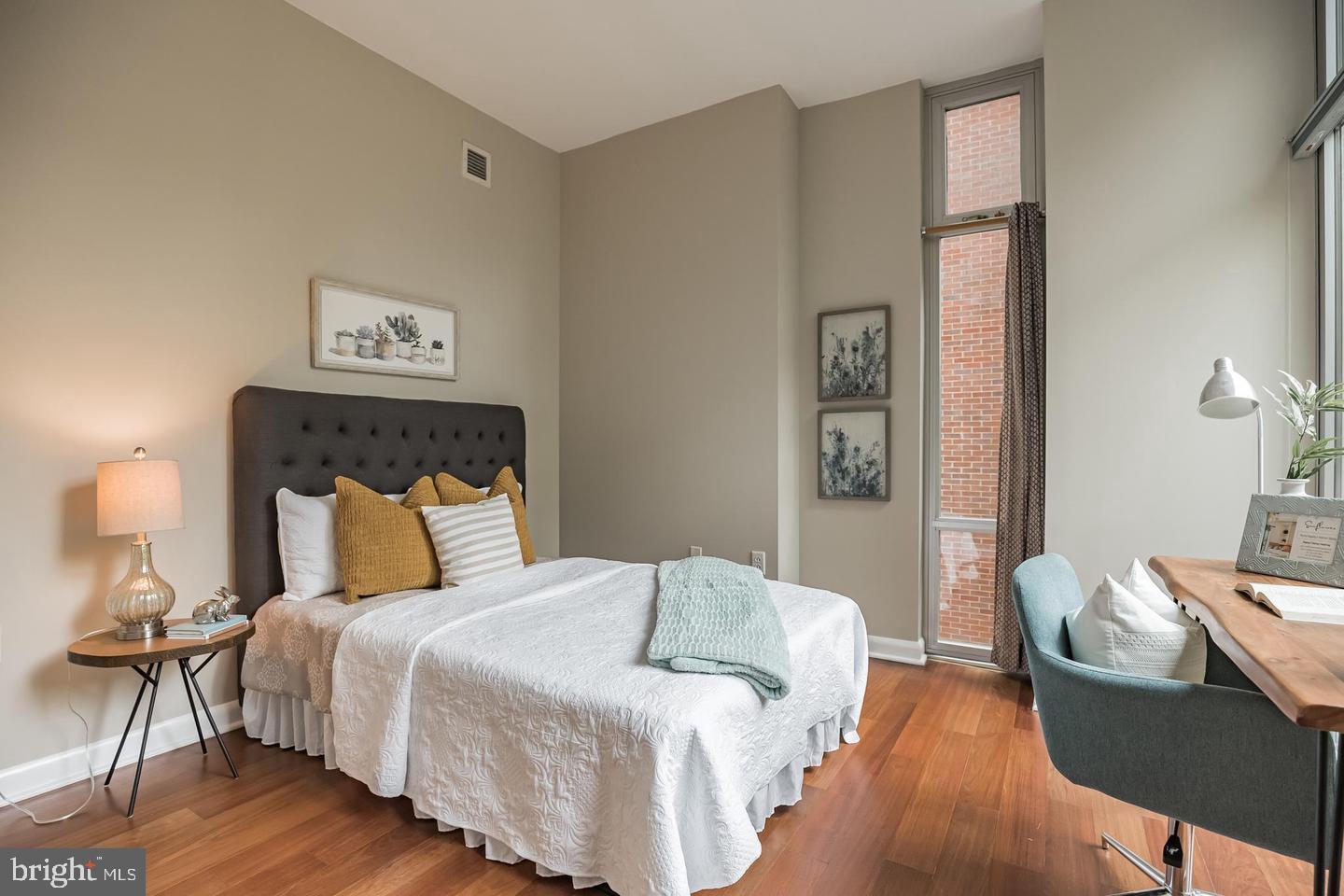 22 South Front Street, Unit 207 Philadelphia, PA 19106 - Photo 3 of 32 a bedroom with a bed and wooden floor