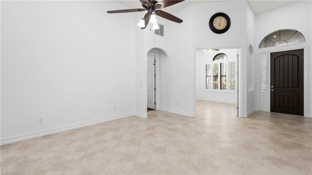 8856 Lely Island Circle Naples, FL 34113 - Photo 12 of 50 Entrance foyer with arched walkways, a ceiling fan, a high ceiling, and light tile patterned floors