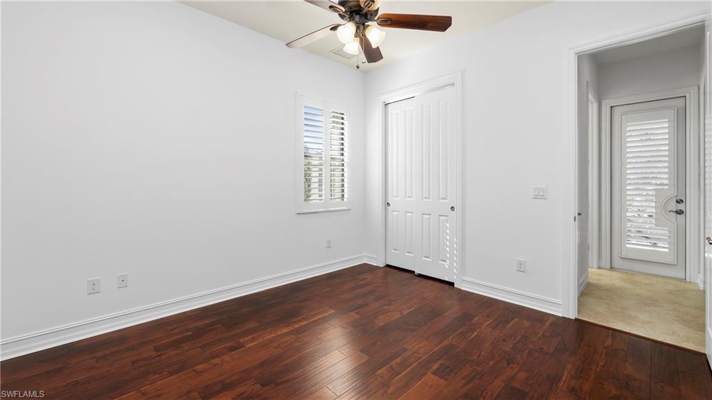 8856 Lely Island Circle Naples, FL 34113 - Photo 27 of 50 Unfurnished bedroom with dark wood-type flooring, ceiling fan, and a closet
