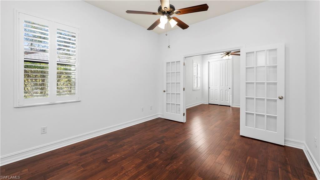 8856 Lely Island Circle Naples, FL 34113 - Photo 27 of 50 Unfurnished bedroom with dark wood-style flooring and ceiling fan