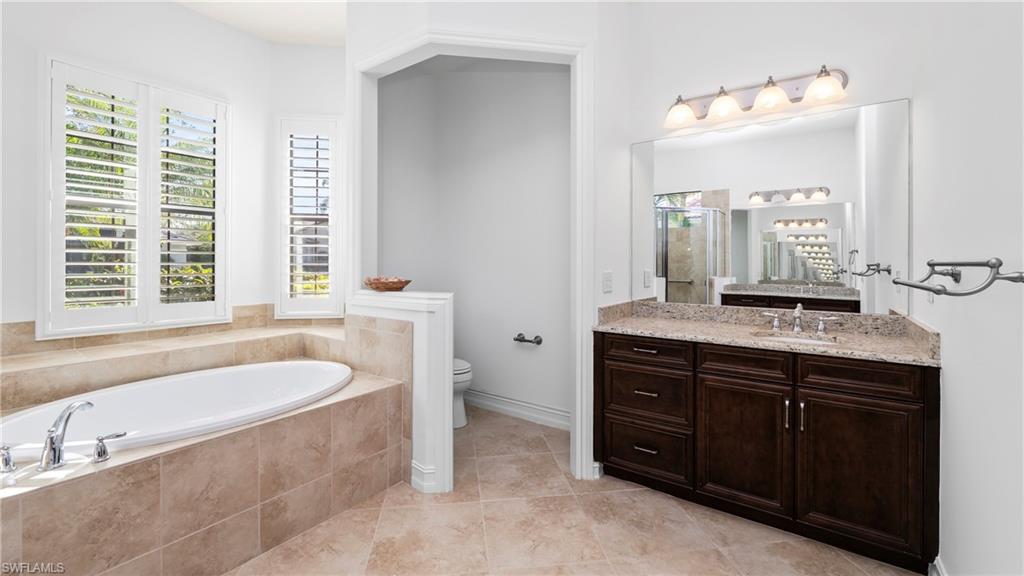 8856 Lely Island Circle Naples, FL 34113 - Photo 31 of 50 Full bath with vanity, a stall shower, a garden tub, and light tile patterned floors