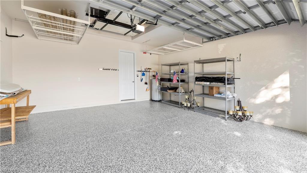 8856 Lely Island Circle Naples, FL 34113 - Photo 35 of 50 Garage featuring water heater and a garage door opener
