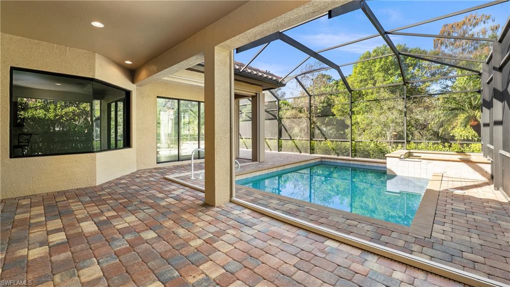 8856 Lely Island Circle Naples, FL 34113 - Photo 36 of 50 Swimming pool with a patio area, glass enclosure, and a sunroom