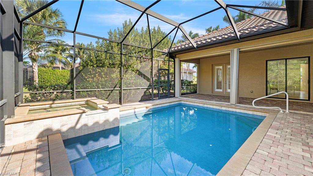 8856 Lely Island Circle Naples, FL 34113 - Photo 38 of 50 Outdoor pool with a sunroom, a patio, a lanai, and a hot tub