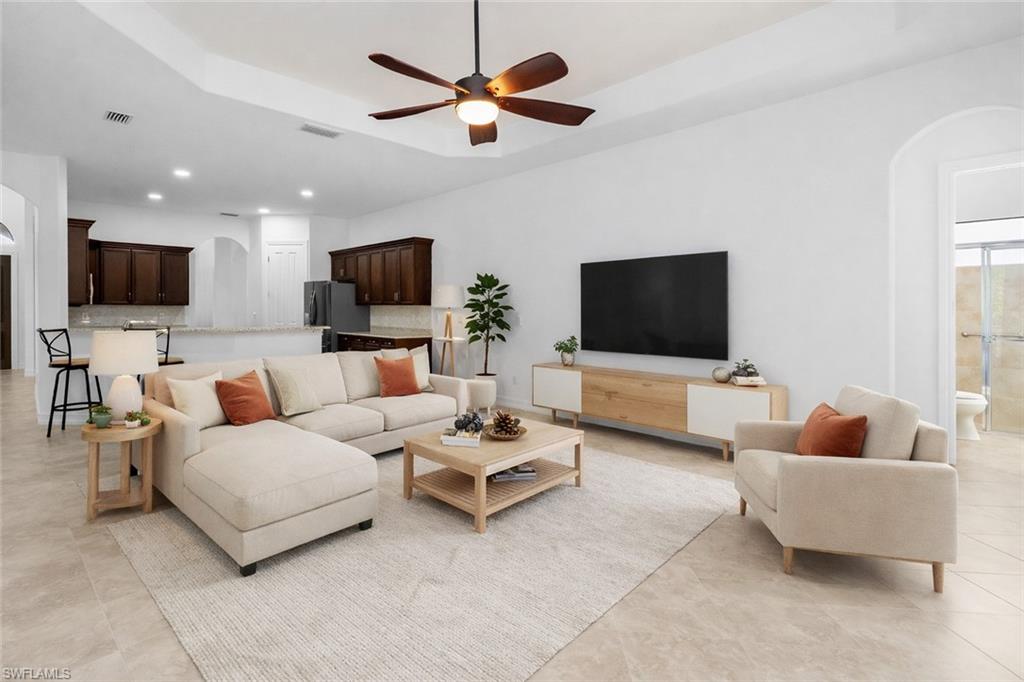 8856 Lely Island Circle Naples, FL 34113 - Photo 6 of 50 Virtually Staged Living area featuring arched walkways, a raised ceiling, a ceiling fan, and recessed lighting
