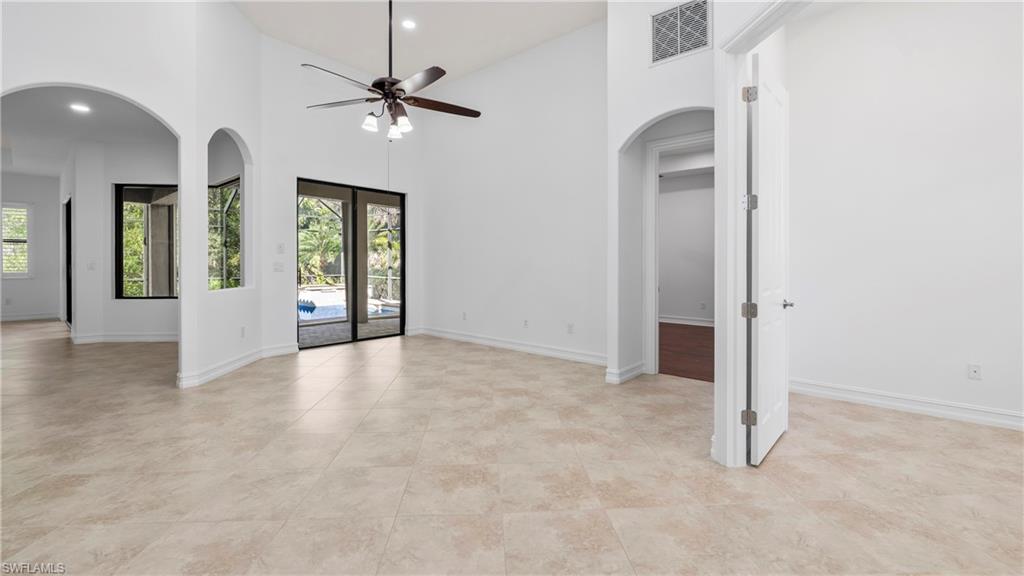 8856 Lely Island Circle Naples, FL 34113 - Photo 9 of 50 Spare room featuring arched walkways, a high ceiling, ceiling fan, and recessed lighting