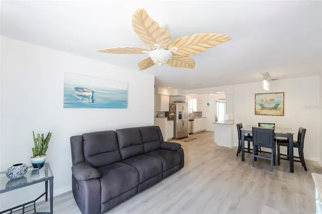 a living room with furniture a dining table and a ceiling fan