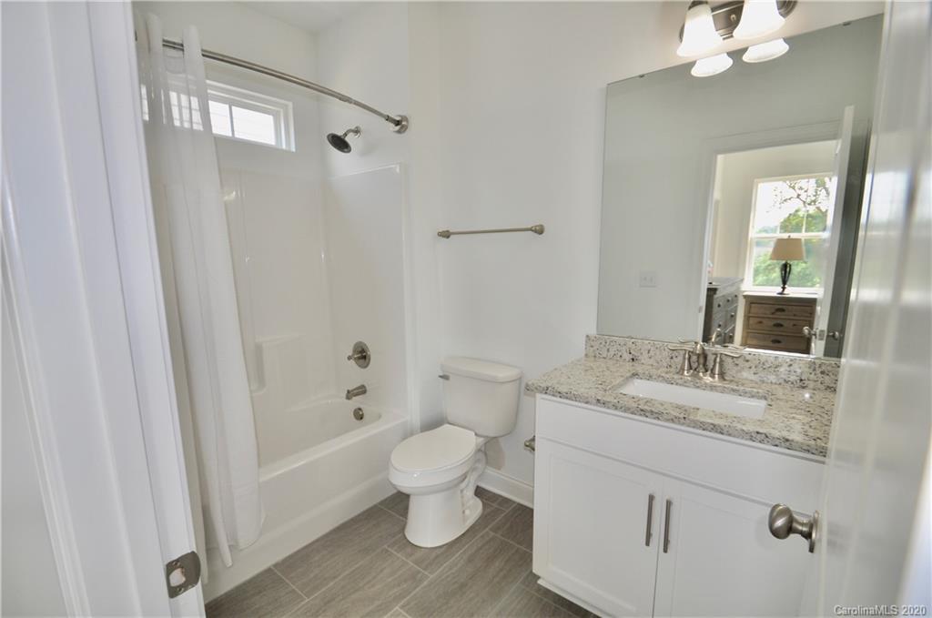 235 Keener Boulevard Belmont, NC 28012 - Photo 20 of 29 a bathroom with a granite countertop sink toilet a large mirror a bathtub and shower