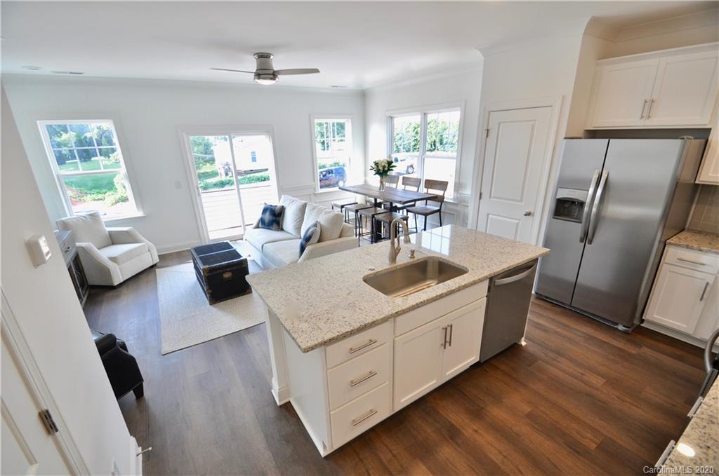235 Keener Boulevard Belmont, NC 28012 - Photo 6 of 29 a kitchen with stainless steel appliances granite countertop a sink dishwasher a refrigerator a stove a dining table and chairs with wooden floor