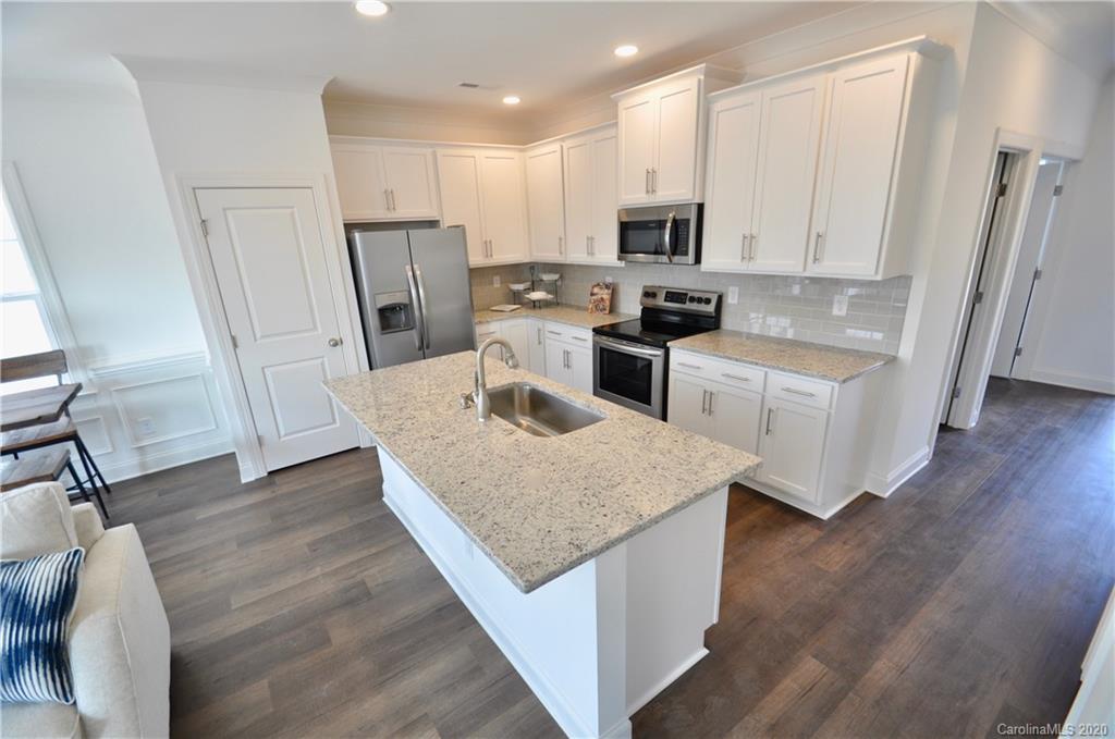 235 Keener Boulevard Belmont, NC 28012 - Photo 7 of 29 a kitchen with white cabinets and stainless steel appliances