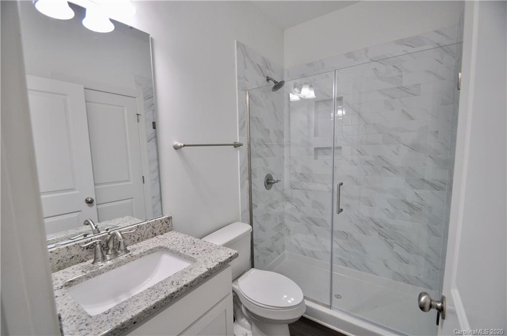 235 Keener Boulevard Belmont, NC 28012 - Photo 9 of 29 a bathroom with a granite countertop sink toilet a mirror and shower