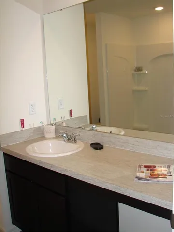 a bathroom with a granite countertop sink and a mirror