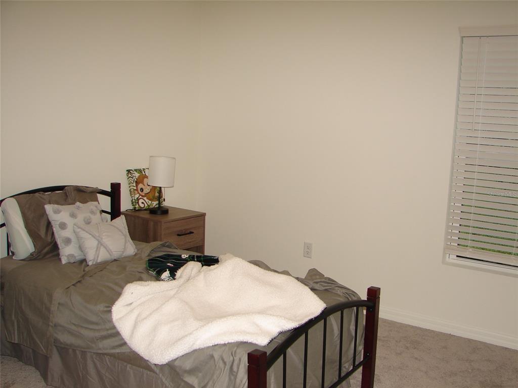 136 Sea Trail Palm Coast, FL 32164 - Photo 18 of 29 a bed sitting in a bedroom next to a window