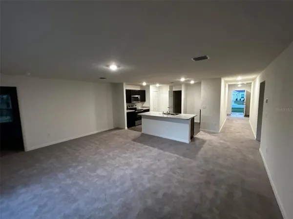 a view of a livingroom with a kitchen counter tops and white walls