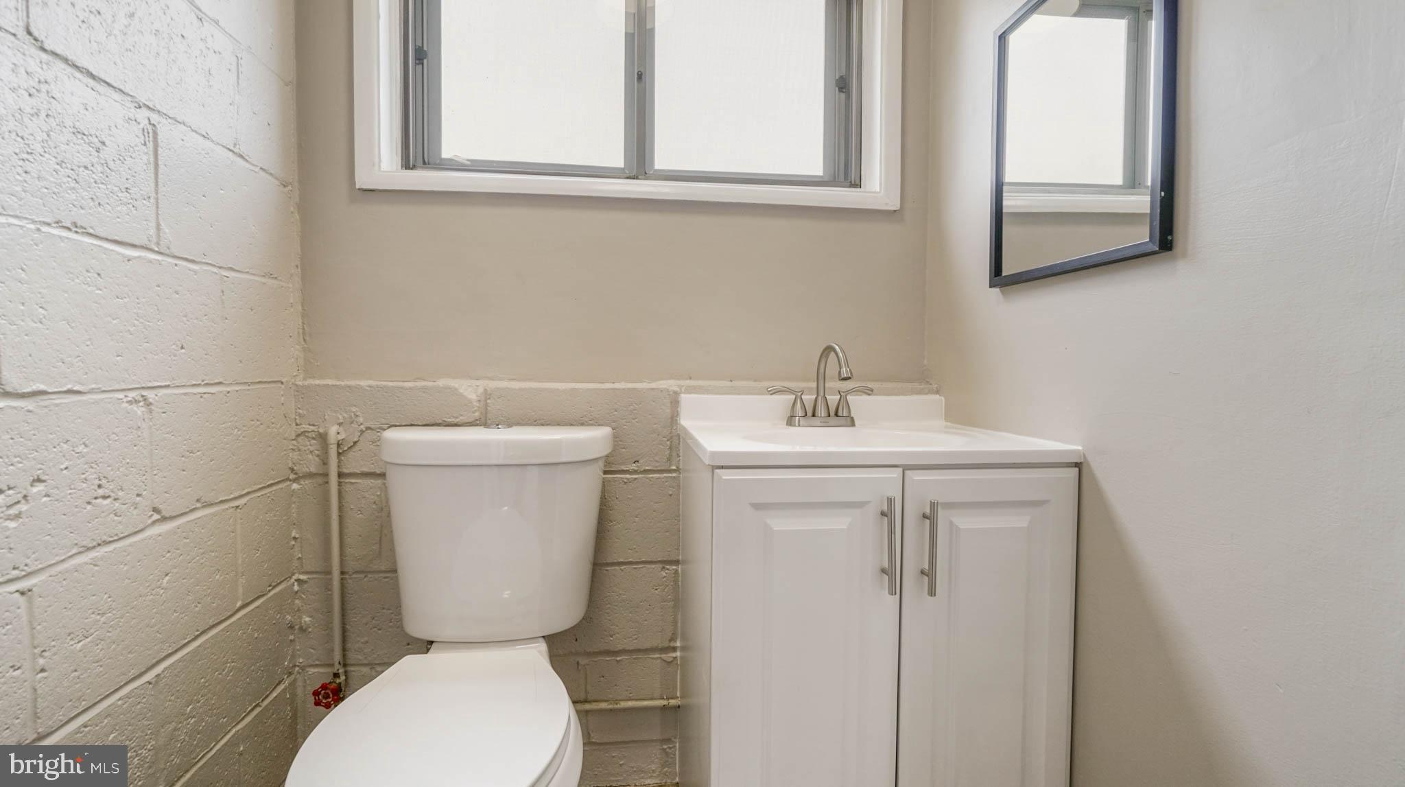 5932 Charnwood Road Baltimore, MD 21228 - Photo 14 of 21 a bathroom with a toilet sink and mirror