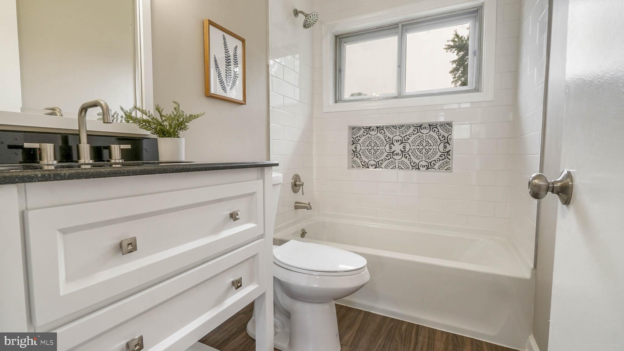 5932 Charnwood Road Baltimore, MD 21228 - Photo 7 of 21 a bathroom with a sink a toilet and shower
