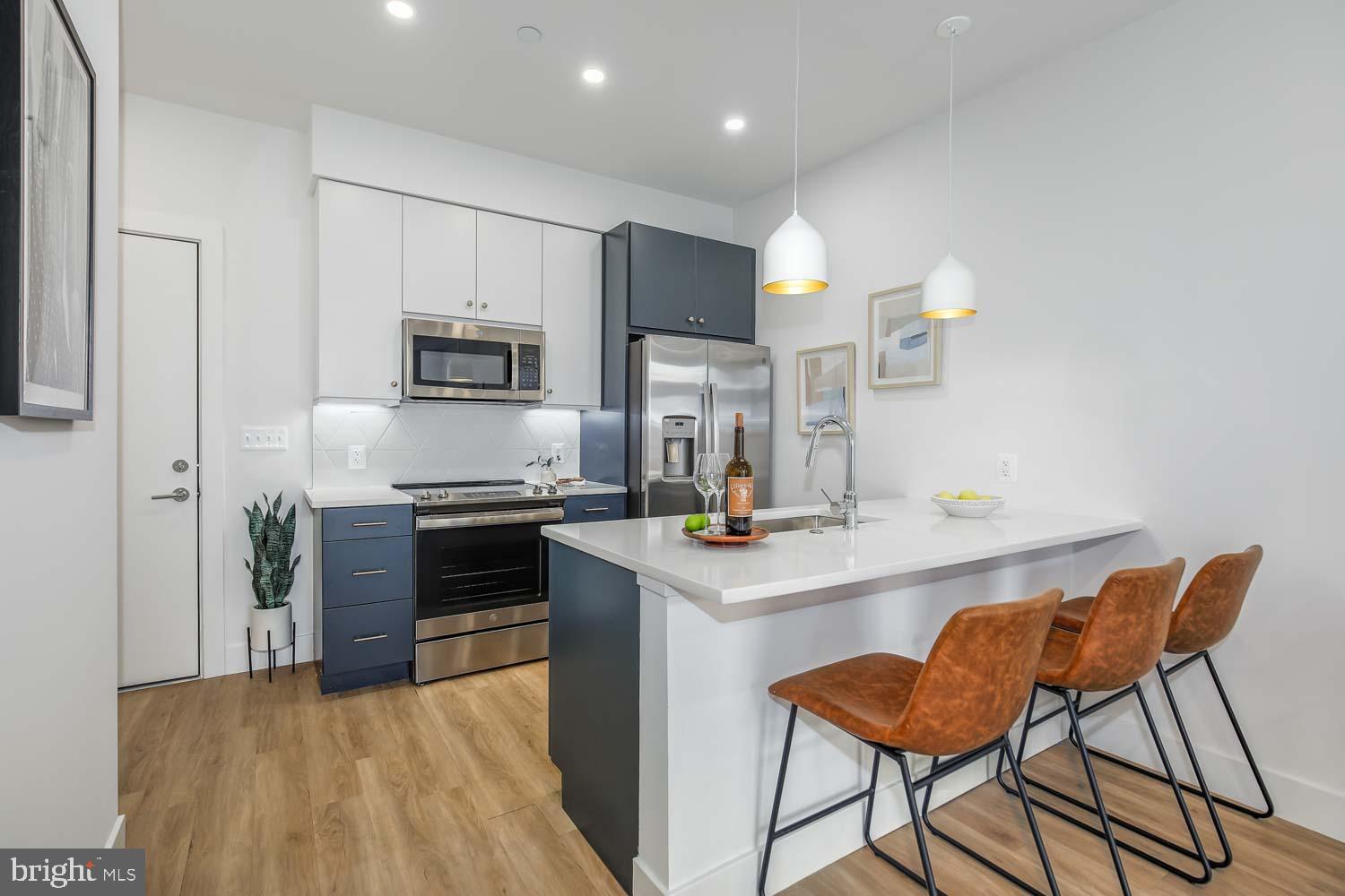 2310 4th Street Northeast, Unit 422 Washington, DC 20002 - Photo 2 of 18 a kitchen with stainless steel appliances a stove a sink refrigerator and a microwave