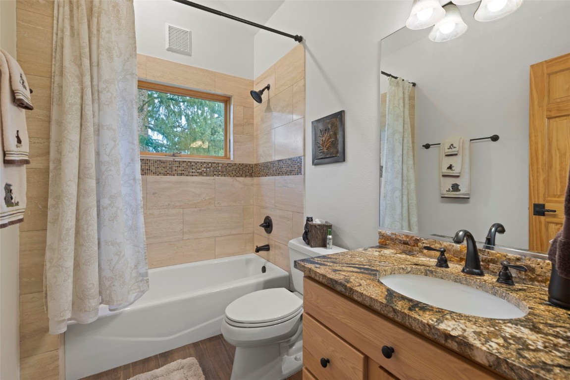 736 Wild Rose Road Silverthorne, CO 80498 - Photo 23 of 49 a bathroom with a granite countertop sink mirror vanity bathtub and a toilet