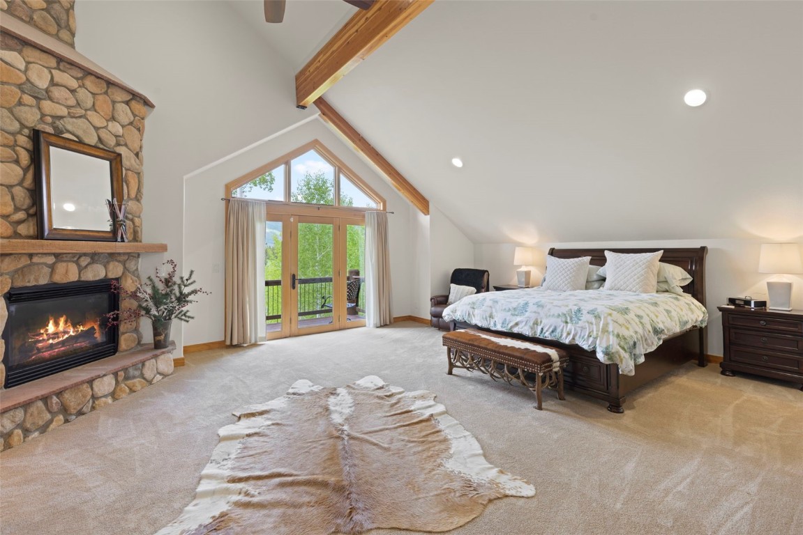 736 Wild Rose Road Silverthorne, CO 80498 - Photo 25 of 49 a bedroom with a bed a fireplace and a large window