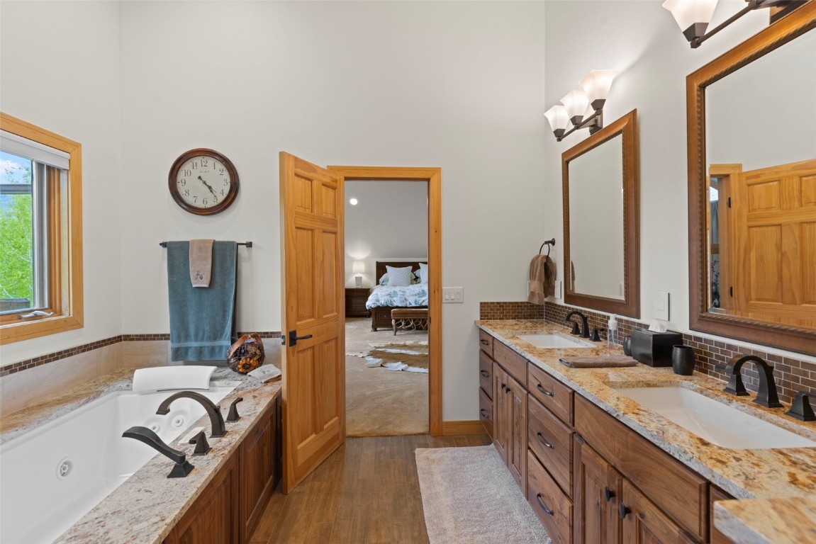 736 Wild Rose Road Silverthorne, CO 80498 - Photo 29 of 49 a bathroom with a granite countertop tub sink double vanity granite and a large mirror