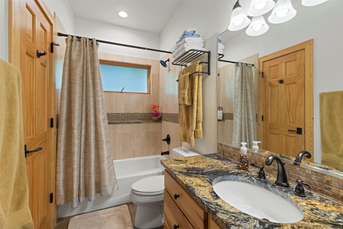 736 Wild Rose Road Silverthorne, CO 80498 - Photo 41 of 49 a bathroom with a granite countertop sink toilet a mirror a vanity and shower