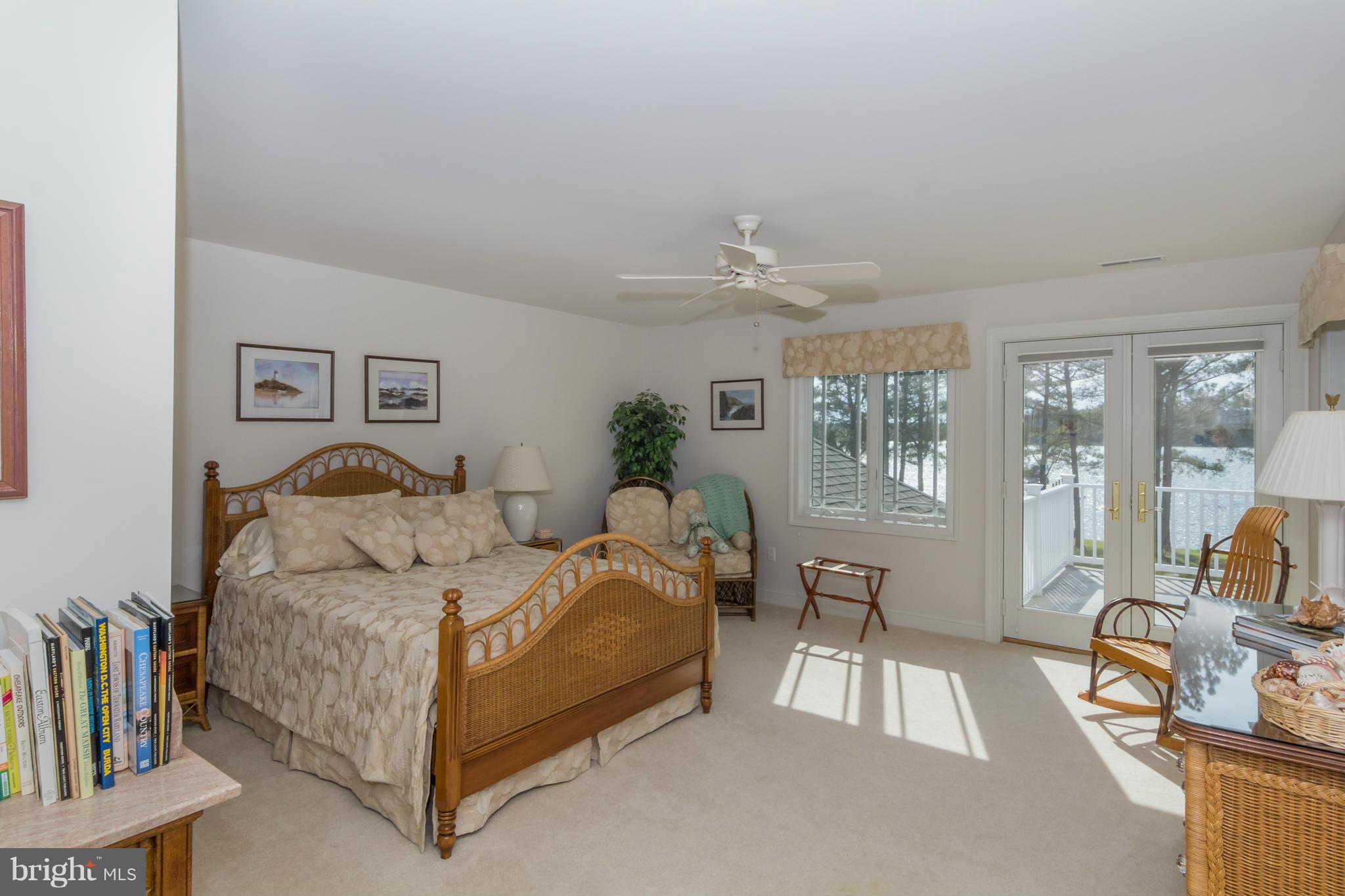 8092 Church Neck Road St. Michaels, MD 21663 - Photo 18 of 27 a spacious bedroom with a bed and large windows